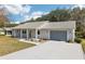 Well-manicured single-story home featuring an attached garage and a tidy front lawn with a charming front entrance at 1517 New Abbey Ave, Leesburg, FL 34788