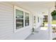 Charming covered front porch featuring classic white columns, hanging flower basket, and well-lit entrance at 1517 New Abbey Ave, Leesburg, FL 34788