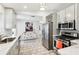 Modern kitchen with stainless steel appliances, white cabinets, and marble countertops at 1517 New Abbey Ave, Leesburg, FL 34788