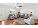 Bright living room with hardwood floors, a ceiling fan, and comfortable seating with stylish decor and natural light at 1517 New Abbey Ave, Leesburg, FL 34788