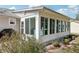 Enclosed sunroom with many windows overlooking lush landscaping at 1517 New Abbey Ave, Leesburg, FL 34788