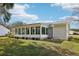 Bright sunroom with multiple windows offering panoramic views of the landscaped backyard at 1517 New Abbey Ave, Leesburg, FL 34788