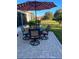 Outdoor patio with a dining set under a red and white striped umbrella at 15842 Sw 11Th Terrace Rd, Ocala, FL 34473