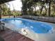 Freeform swimming pool with surrounding deck and trees at 17840 Se 28Th Pl, Silver Springs, FL 34488