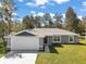 Newly constructed home with gray siding, white garage door, and landscaped lawn at 30 Hemlock Run, Ocala, FL 34480