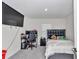 Bedroom featuring a black headboard, large TV, desk and gray carpeting at 3775 Sw 127Th Lane Rd, Ocala, FL 34473