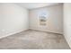 A standard bedroom showing neutral walls, plush carpet, and a window providing natural light at 4470 Nw 2Nd Ct, Ocala, FL 34475