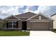 Charming single-story home featuring a two-car garage, neutral paint, manicured lawn, and stylish architectural details at 4763 Sw 88Th Ln, Ocala, FL 34476