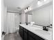 Bright bathroom with a dual sink vanity, large mirror, and a shower-tub combo with white tile at 6215 Se 13Th St, Ocala, FL 34472