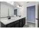 Bright bathroom featuring a double vanity with black hardware and a large mirror at 6215 Se 13Th St, Ocala, FL 34472
