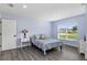 Cozy bedroom with a large window providing natural light, complemented by a light blue color palette at 6215 Se 13Th St, Ocala, FL 34472