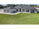 Stunning single-story home featuring a manicured lawn, gray roof, and a beautiful red front door at 6215 Se 13Th St, Ocala, FL 34472