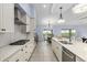 Long, bright kitchen featuring stainless appliances, white cabinets, herringbone backsplash, and quartz countertops at 6215 Se 13Th St, Ocala, FL 34472