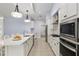 Modern kitchen featuring stainless appliances, white cabinets, herringbone backsplash, and quartz countertops at 6215 Se 13Th St, Ocala, FL 34472