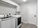 Laundry room with modern washer and dryer, cabinet, and folding counter for convenience at 6215 Se 13Th St, Ocala, FL 34472