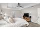 Bright main bedroom featuring a tray ceiling, ceiling fan, and a television with cabinet at 6215 Se 13Th St, Ocala, FL 34472
