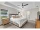 Bright main bedroom featuring a tray ceiling, ceiling fan, and plush carpet at 6215 Se 13Th St, Ocala, FL 34472