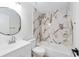 Beautiful bathroom featuring marble tile accent wall and new vanity with updated fixtures at 6302 Nw 57Th Ave, Ocala, FL 34482