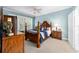 Spacious bedroom with a wooden post bed, blue bedding, and wood furniture at 7454 Sw 101St Ave, Ocala, FL 34481