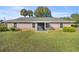 Charming one-story home featuring a pink stucco exterior and landscaping at 7601 Se 22Nd Ave, Ocala, FL 34480