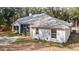 Exterior of home with a screened in porch and a beautifully landscaped yard, surrounded by mature trees at 7670 Se 110Th Street Rd, Belleview, FL 34420