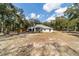 The home's backyard is spacious and well-treed, with a view of the rear exterior of the home at 7670 Se 110Th Street Rd, Belleview, FL 34420