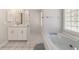 Bathroom featuring a soaking tub, walk in glass-blocked shower, and vanity at 7670 Se 110Th Street Rd, Belleview, FL 34420