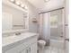 Bathroom featuring a shower with white tiles, white vanity, and large mirror with lighting at 7670 Se 110Th Street Rd, Belleview, FL 34420