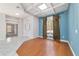 Cozy living room features hardwood flooring, a decorative window with curtains, and a connecting hallway at 7670 Se 110Th Street Rd, Belleview, FL 34420