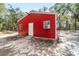 Close-up of a vibrant red outbuilding featuring a practical design, enhancing the property's utility and visual appeal at 7670 Se 110Th Street Rd, Belleview, FL 34420