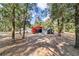 A red outbuilding with a gray door and a gray lean-to are nestled among mature trees in a natural setting at 7670 Se 110Th Street Rd, Belleview, FL 34420