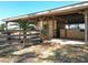 A tan barn stall with a wooden fence and a green feeding container at 7688 Se 135Th St, Summerfield, FL 34491