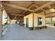 Long shot of a beige barn with an outdoor patio, a green door, and a concrete patio at 7688 Se 135Th St, Summerfield, FL 34491