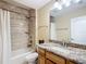 Tiled full bathroom with shower and tub combination, granite countertop, and wood cabinets at 7688 Se 135Th St, Summerfield, FL 34491