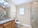 Cozy bathroom with glass enclosed shower, vanity, and granite countertop at 7688 Se 135Th St, Summerfield, FL 34491