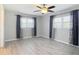 Bedroom featuring gray walls, wood-look flooring, and two windows at 7688 Se 135Th St, Summerfield, FL 34491