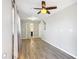 A gray bedroom with light-colored wood floors, a ceiling fan, and two white doors at 7688 Se 135Th St, Summerfield, FL 34491