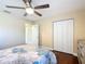 Warm bedroom with hardwood floors, a ceiling fan, and large window with shutter shades at 7688 Se 135Th St, Summerfield, FL 34491