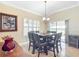 Bright dining room featuring plantation shutters, travertine floors, a dark wood table and updated lighting at 7688 Se 135Th St, Summerfield, FL 34491