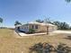 Side exterior view featuring a well-manicured lawn, a small garden, and a three-car garage at 7688 Se 135Th St, Summerfield, FL 34491