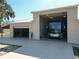 View of a tan garage with a concrete driveway and a black and grey RV parked inside at 7688 Se 135Th St, Summerfield, FL 34491