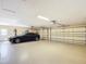 A clean and spacious garage with a luxury car and three garage doors at 7688 Se 135Th St, Summerfield, FL 34491