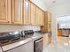 Well-equipped laundry room with wooden cabinets, granite countertop, and modern, stainless steel washer and dryer at 7688 Se 135Th St, Summerfield, FL 34491