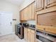 Spacious laundry room with stainless steel washer and dryer, cabinetry, granite countertop, and travertine flooring at 7688 Se 135Th St, Summerfield, FL 34491