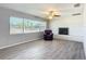 Cozy living room showcasing wood-look flooring, a brick fireplace, and large windows at 7688 Se 135Th St, Summerfield, FL 34491