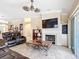 Open living room with travertine floors, a fireplace, large TV, and a unique ceiling fan at 7688 Se 135Th St, Summerfield, FL 34491