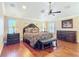 Spacious main bedroom features a decorative ceiling fan, hardwood floors, and plantation shutters at 7688 Se 135Th St, Summerfield, FL 34491