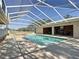 Enclosed pool featuring a sunroom area and brick fire pit at 7688 Se 135Th St, Summerfield, FL 34491