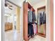 View of the walk-in closet with wood shelving, rods, and access to the bathroom at 7688 Se 135Th St, Summerfield, FL 34491