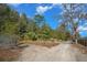 Sandy driveway leading into a wooded area at 7740 Sw 70Th Ave, Ocala, FL 34476